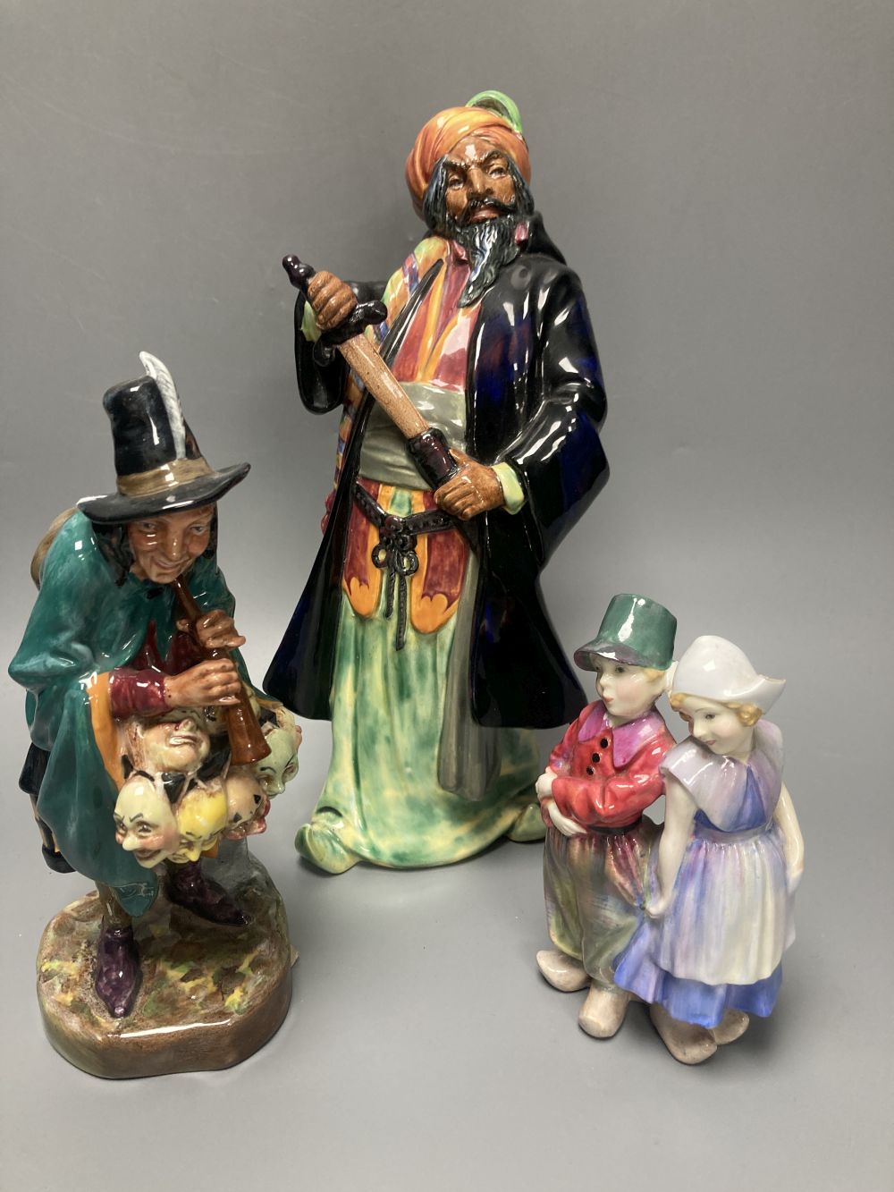 Three Doulton figures: Willy Wont He, HN7818, The Mask Seller, HN2103 and Blue Beard HN2105, tallest 27cm